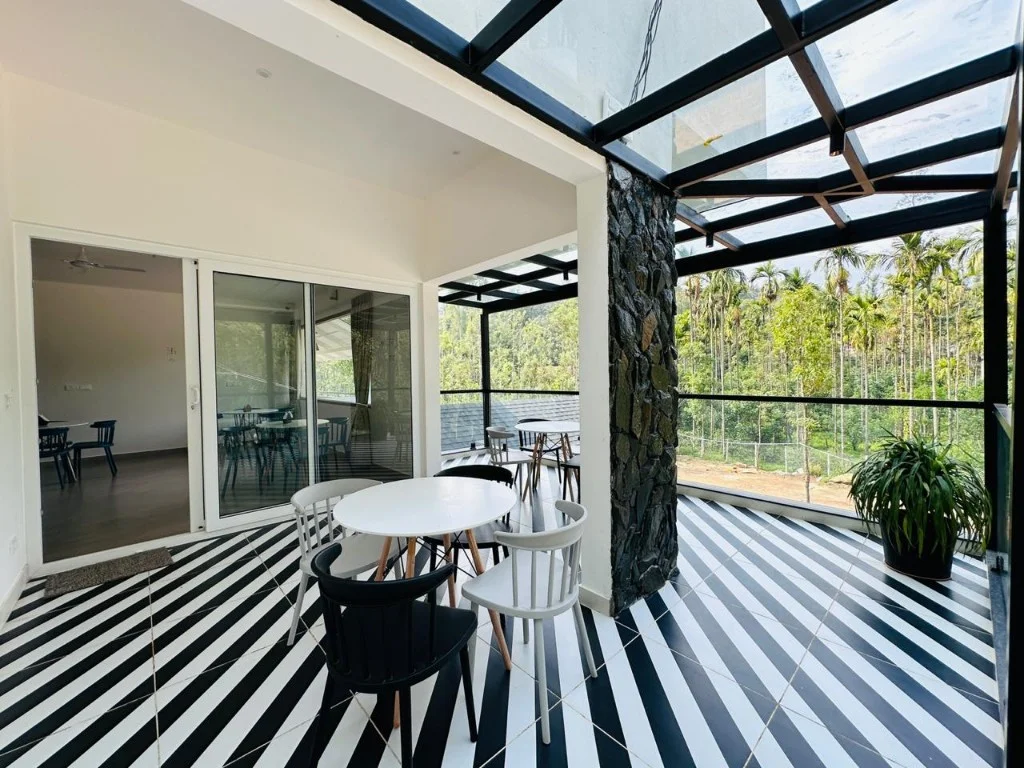Glass-roof balcony with striped floor overlooking dense green forest at Homestay P3