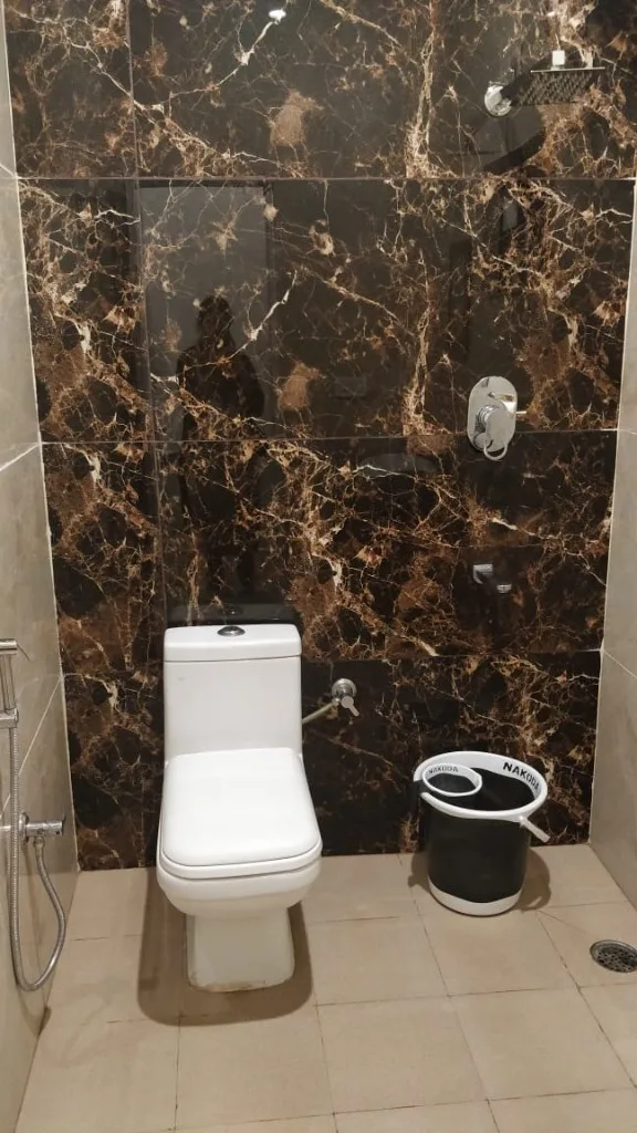Modern bathroom with marble-pattern tiles and rainfall shower at Homestay P3