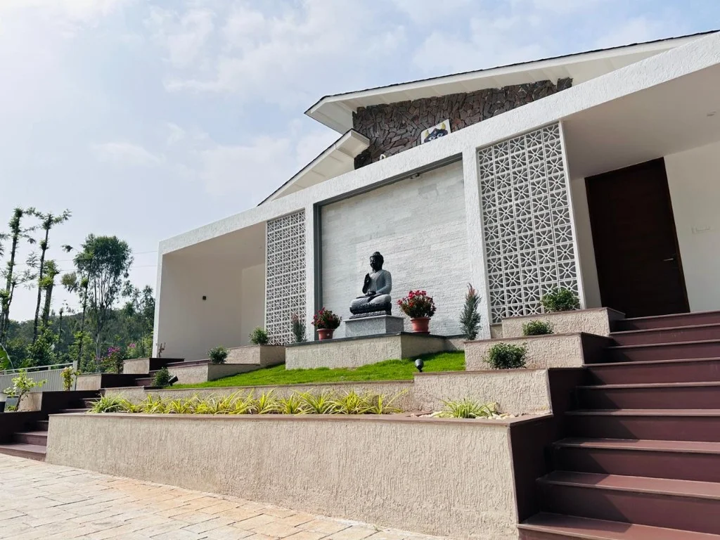 Peaceful Buddha entrance with tiered planters at Trip Chikmagalur Homestay P3