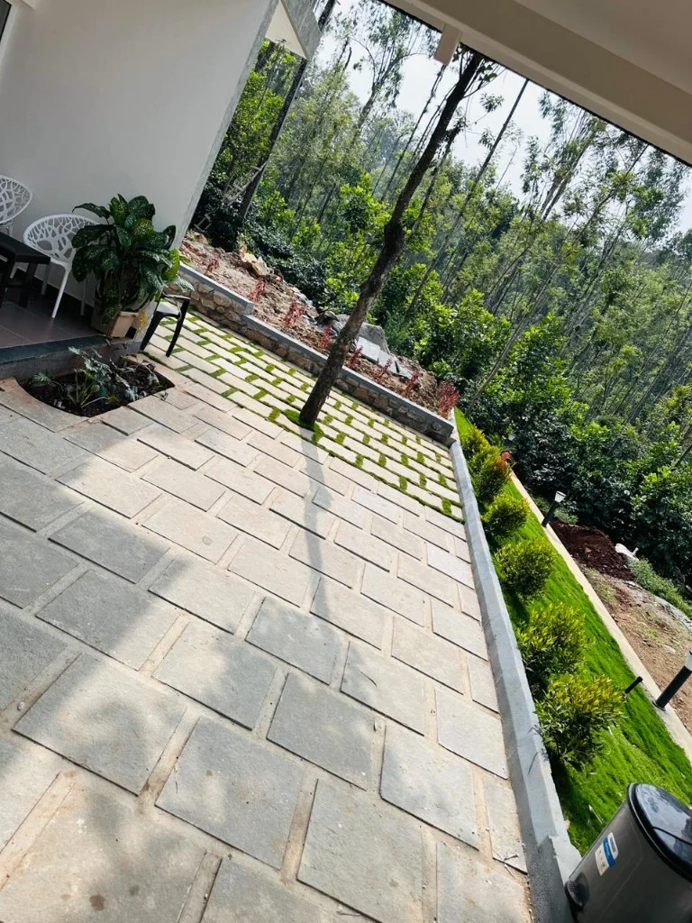 Stone patio with forest views and modern outdoor seating at Homestay P3