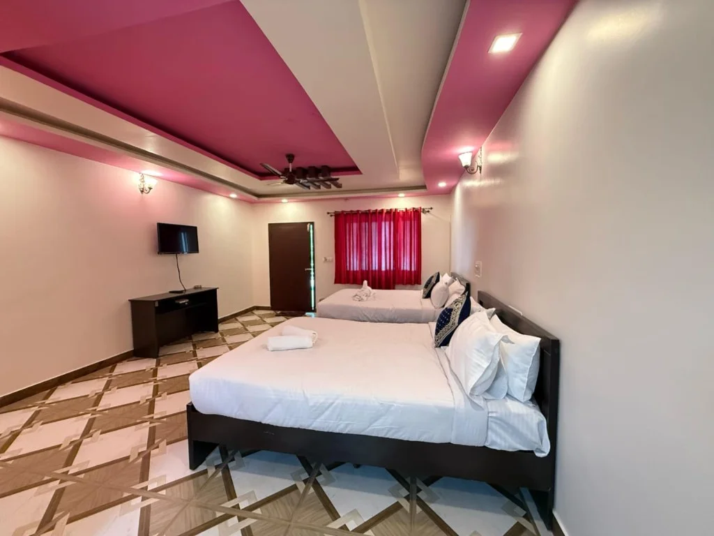 Family suite with pink ceiling feature and twin beds at Resort P2 Chikmagalur