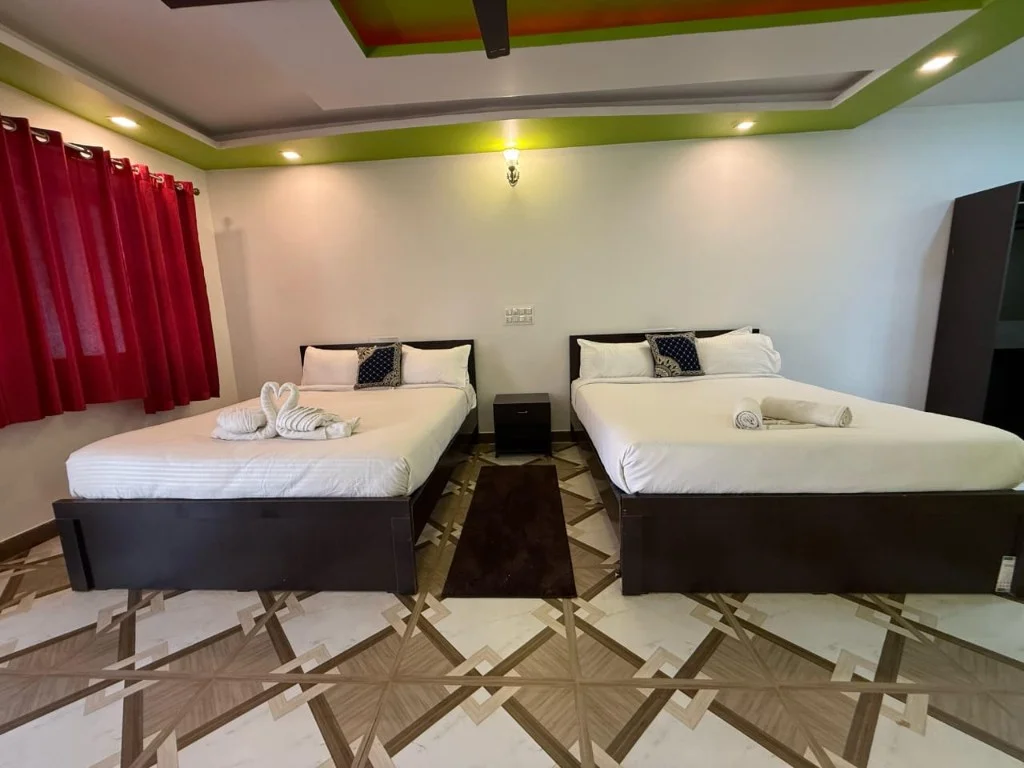 Spacious twin bedroom with green accent ceiling and white linens at Resort P2