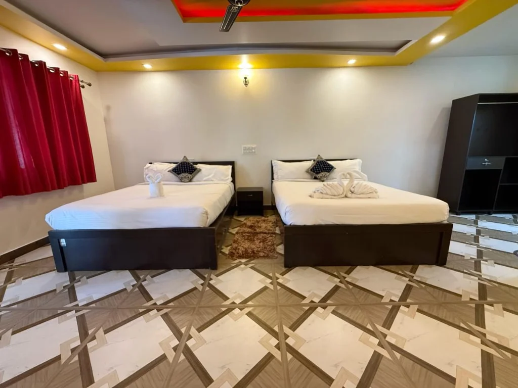 Twin double beds with towel swan decor and red accent ceiling at Trip Chikmagalur Resort P2